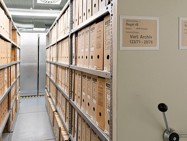 Foto eines Archivmagazins mit Gleitregalen in denen Unterlagen verwahrt werden