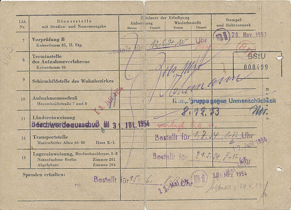 Der Zettel ist mit Stempeln und Unterschriften der zahlreichen Stellen übersäht, die Flüchtende im Notaufnahmelager Berlin-Marienfelde zu besuchen hatten.