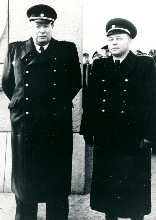 Schwarz-Weiß-Foto zweier Männer in Uniform die nebeneinander stehen.