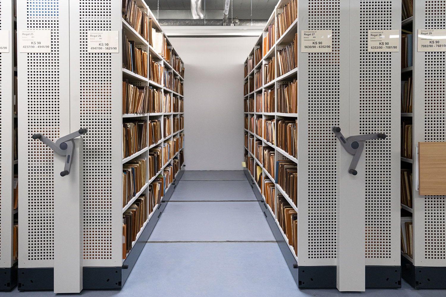 Foto eines Archivmagazins mit Gleitregalen in denen Unterlagen verwahrt werden