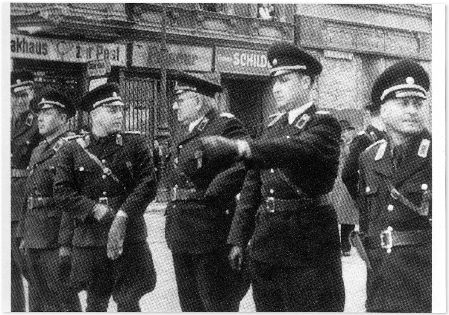 Fünf Männer in Polizeiuniformen stehen nebeneinander in einer Reihe auf einer Straße. 