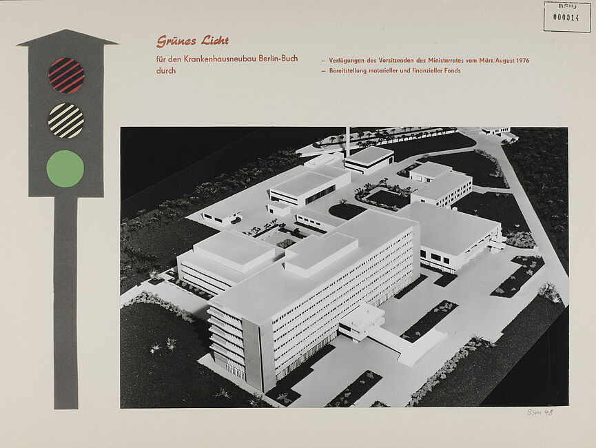 Das Blatt zeigt am linken Bildrand die Zeichnung einer Ampel auf "Grün", rechts daneben ein Foto eines Architekturmodells des Stasi-Krankenhauses in Berlin-Buch. Darüber ein Textfeld: „Grünes Licht für den Krankenhausneubau Berlin-Buch durch Verfügungen des Vorsitzenden des Ministerrats vom März 1976, Bereitstellung materieller und finanzieller Fonds.“