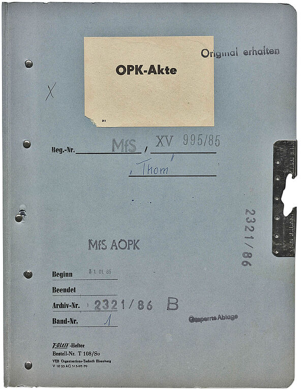 Aktendeckel der OPK "Thom" gegen zwei DDR-Bürger, die 1984 über die Botschaft der Bundesrepublik Deutschland in Prag ausreisen wollten Blauer Aktendeckel, oben mittig ist ein Aufkleber mit der Aufschrift "OPK-Akte".
