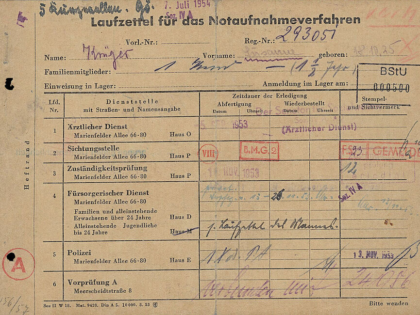 Der Zettel ist mit Stempeln und Unterschriften der zahlreichen Stellen übersäht, die Flüchtende im Notaufnahmelager Berlin-Marienfelde zu besuchen hatten.