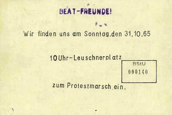 Zettel mit der Aufschrift "Beat-Freunde! Wir finden uns am Sonntag, den 31.10.65 10 Uhr-Leuschnerplatz zum Protestmarsch ein".