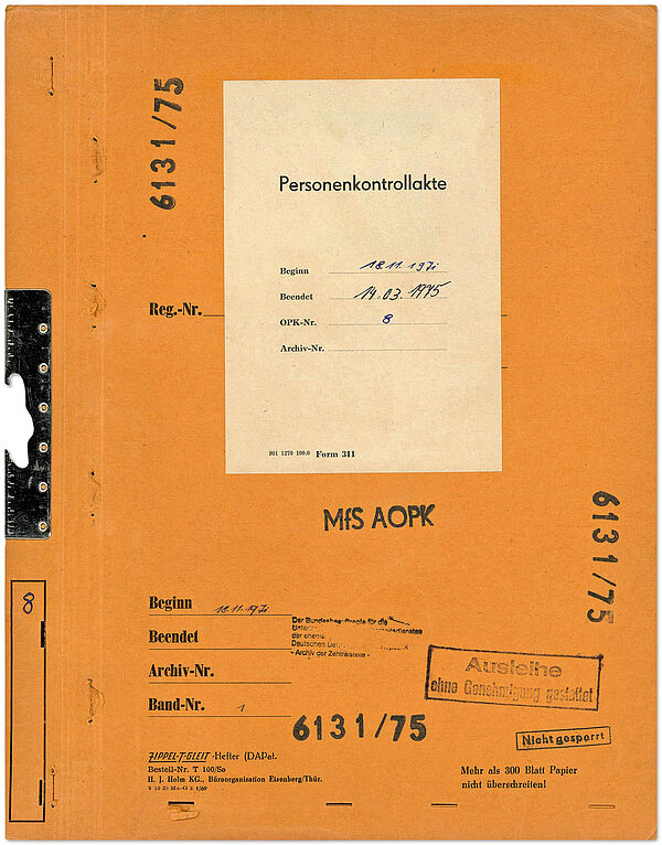 Aktendeckel einer 1971 eröffneten und 1975 archivierten OPK zu einem Mitarbeiter der Deutschen Akademie der Landwirtschaftswissenschaften Orangefarbener Aktendeckel, in der Mitte ist ein Aufkleber mit der Aufschrift "Personenkontrollakte".