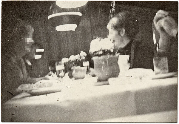 Heimliche Aufnahme von Gästen im Restaurant "Malmö" im Rostocker Interhotel "Warnow", Anfang der 1980er Jahre Quelle: BArch, MfS, BV Rostock, Abt. VIII, Nr. 24, Teil 3, Bl. 285 Leicht unscharfes, anscheinend heimlich aufgenommenes Schwarz-Weiß-Foto zweier weiblicher Personen, die an einem Tisch sitzen und sich lachend unterhalten. Am rechten Bildrand sind die zwei Hände einer weiteren Person zu erkennen.