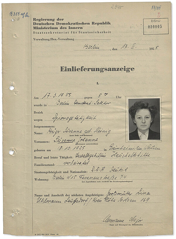 Einlieferungsanzeige in die Stasi-Untersuchungshaft für Susanne Krüger, 17. März 1955; Quelle: BArch, MfS, GH 108/55, Bd. 6, Bl. 5 Braunes A4 Formblatt: Neben spärlichen Angaben zu Krügers Festnahme, ihren Personalien und die ihrer Großmutter als nächste Angehörige (schwarze Tinte) enthält das Dokument auch ein schwarz-weiß Passfoto der Festgenommenen.