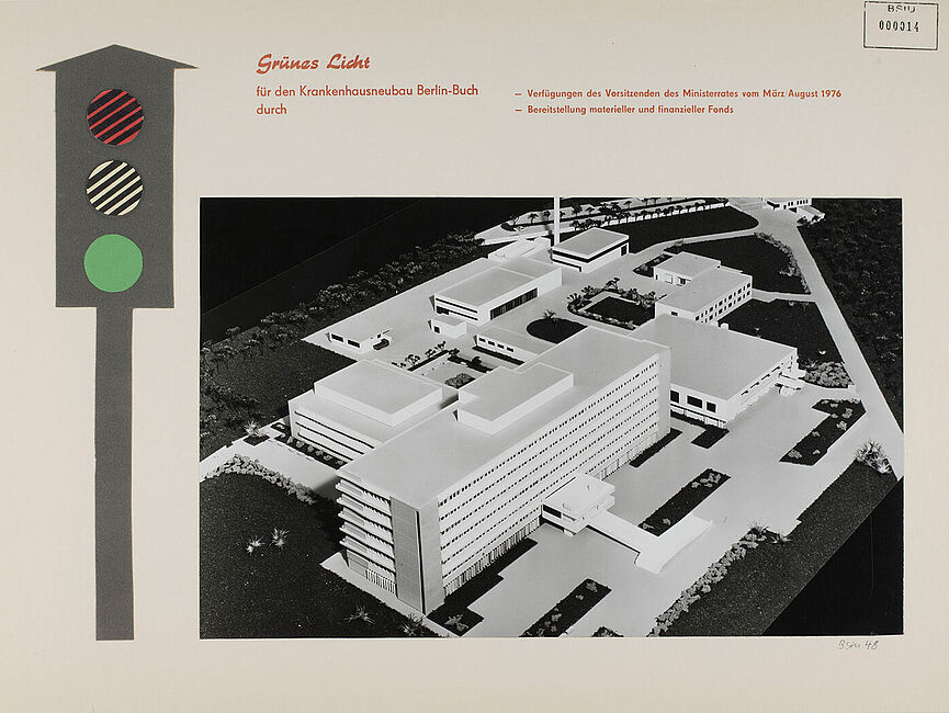 Das Blatt zeigt am linken Bildrand die Zeichnung einer Ampel auf "Grün", rechts daneben ein Foto eines Architekturmodells des Stasi-Krankenhauses in Berlin-Buch. Darüber ein Textfeld: „Grünes Licht für den Krankenhausneubau Berlin-Buch durch Verfügungen des Vorsitzenden des Ministerrats vom März 1976, Bereitstellung materieller und finanzieller Fonds.“