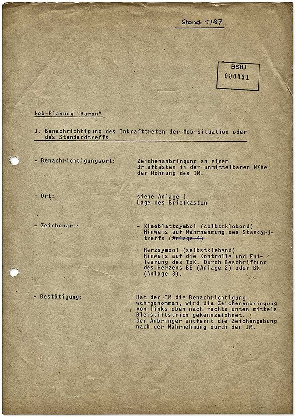 Stasi-Instruktion für die außerplanmäßige Kontaktaufnahme zu IM "Baron" bei kurzfristigen Auftragsänderungen oder Gefahrensituationen ("Mobilmachungs-Situation"), 1987 Die Instruktion legt fest, dass die Stasi in der Nähe des Wohnorts des IM Aufkleber an einem bestimmten Briefkasten anbringt. Mit einem Bleistiftstrich auf dem Aufkleber sollte der IM bestätigen, dass er die Nachricht wahrgenommen hat. Anschließend sollte die Stasi den Aufkleber wieder entfernen.