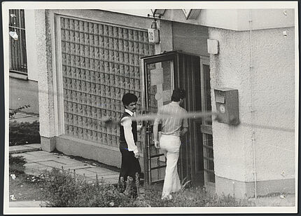 Schwarz-Weiß-Foto zweier Männer, die ein Gebäude betreten.