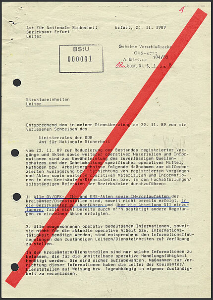 Maschinell beschriebener Zettel, auf dem von links unten nach rechts oben ein dicker roter Strich gedruckt ist. Absender ist der Leiter des Amts für Nationale Sicherheit, Bezirksamt Erfurt. 