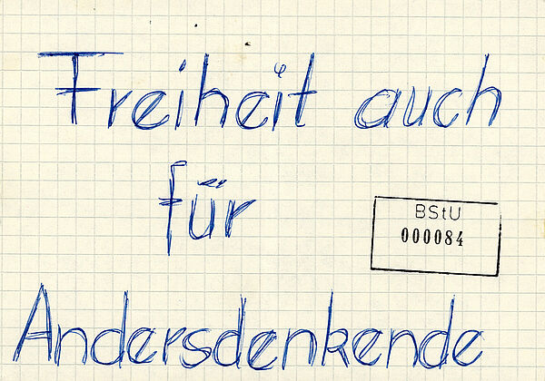 Handgeschriebenes Flugblatt von Sylke Glaser, 15. Februar 1988; Quelle: BArch, MfS, BV Rostock, AU, Nr. 1646/88, Bd. 2, Bl. 84 Karierter Zettel, auf dem mit Kugelschreiber "Freiheit auch für Andersdenkende" geschrieben steht.