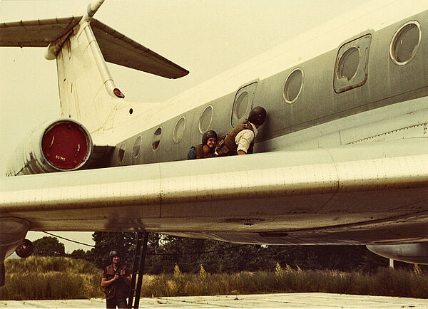 Kampfausbildung der AGM/S im geheimen Objekt "Walli" bei Prenzlau, 80er Jahre Männer mit Helmen auf der Tragfläche eines stationären Flugzeugs