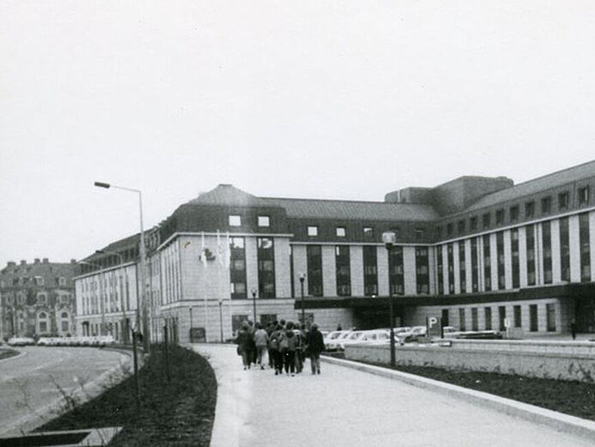 Außenansicht aus einer Bilddokumentation der Stasi über das Interhotel "Bellevue" in Dresden; 1980er Jahre Schwarzweiß Foto: Außenansicht eines 5-stöckigen Gebäudes von einem Gehweg aus