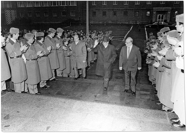 Rudi Mittig begleitet Erich Honecker in der Stasi-Zentrale in Berlin-Lichtenberg durch ein Spalier uniformierter Stasi-Mitarbeiter die Treppenstufen zum Offizierskasino der Stasi in Haus 22 herauf.